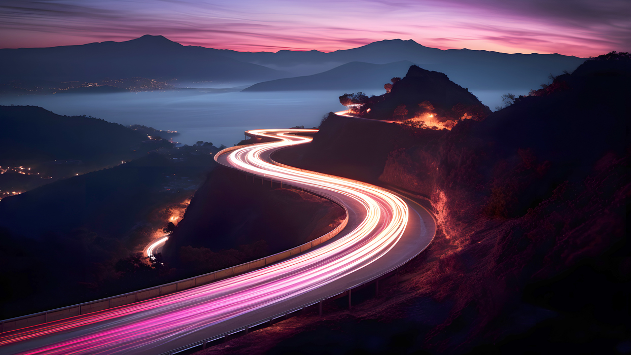 Blurred lights of cars driving along winding road